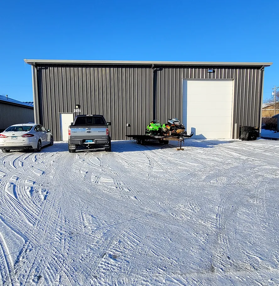 The steel shop building on a clear winter day, snow on the lot