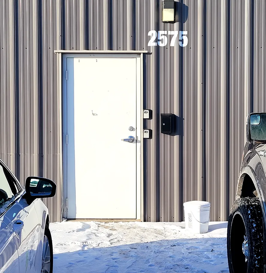 The white side door marked 2575 on the corrugated steel wall