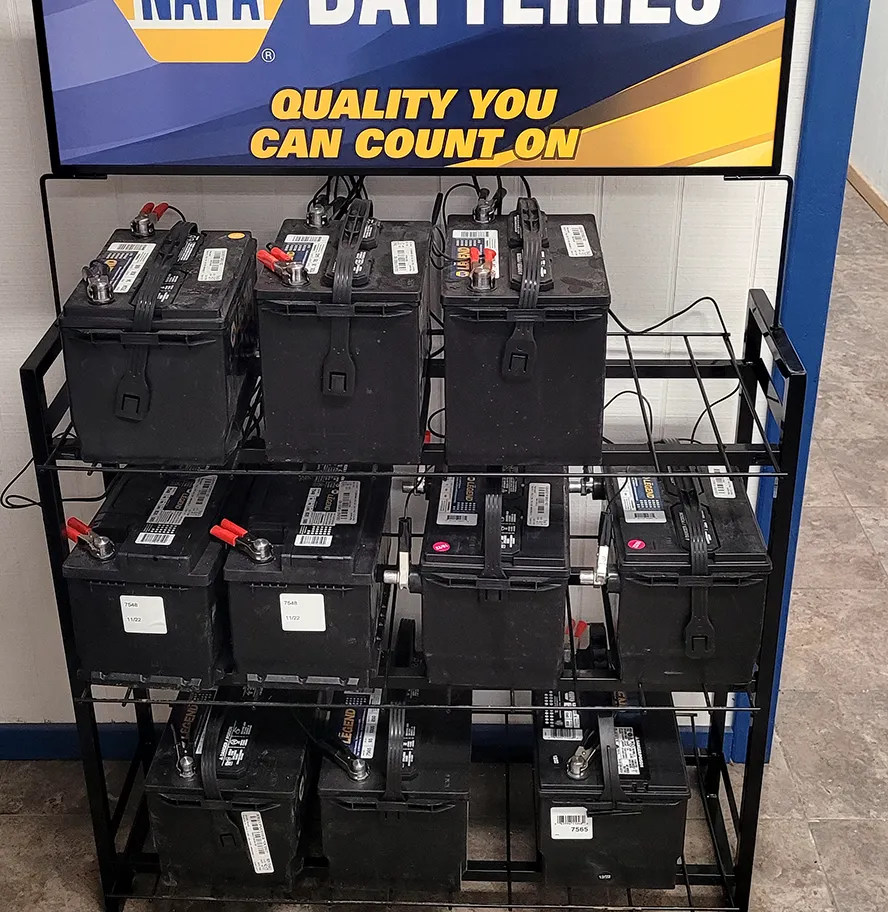 A rack of NAPA batteries under a NAPA Batteries sign