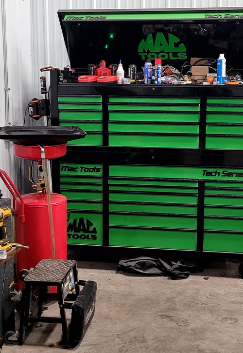 A lime green Mac Tools chest beside a red oil drain